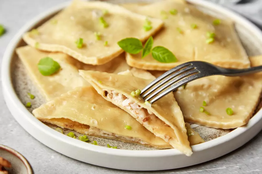 Готовое блюдо равиоли с сыром и грецкими орехами