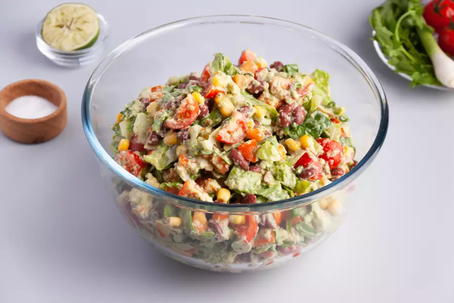 Готовое блюдо салат с фасолью и кукурузой с соусом из авокадо