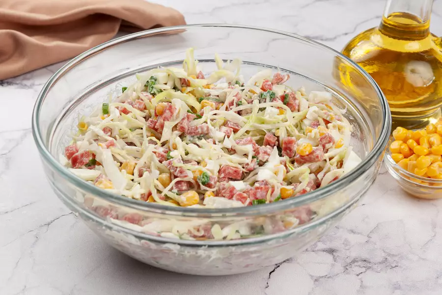 Готовое блюдо салат с копчёной колбасой и кукурузой
