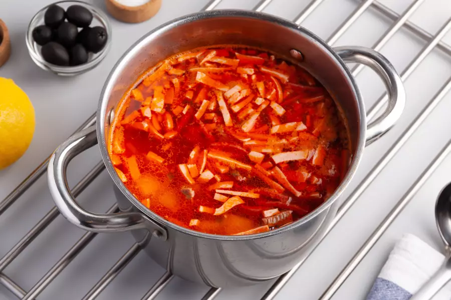 Готовое блюдо солянка с огурцами, колбасой и картошкой