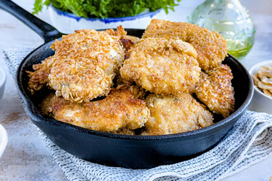 Готовое блюдо курица в панировке на сковороде