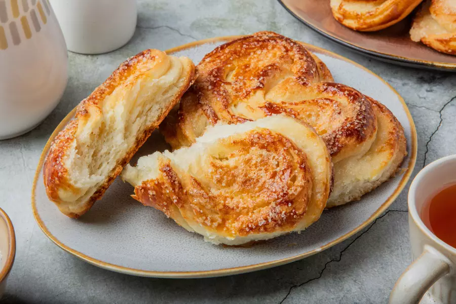 Готовое блюдо плюшки с сахаром на молоке